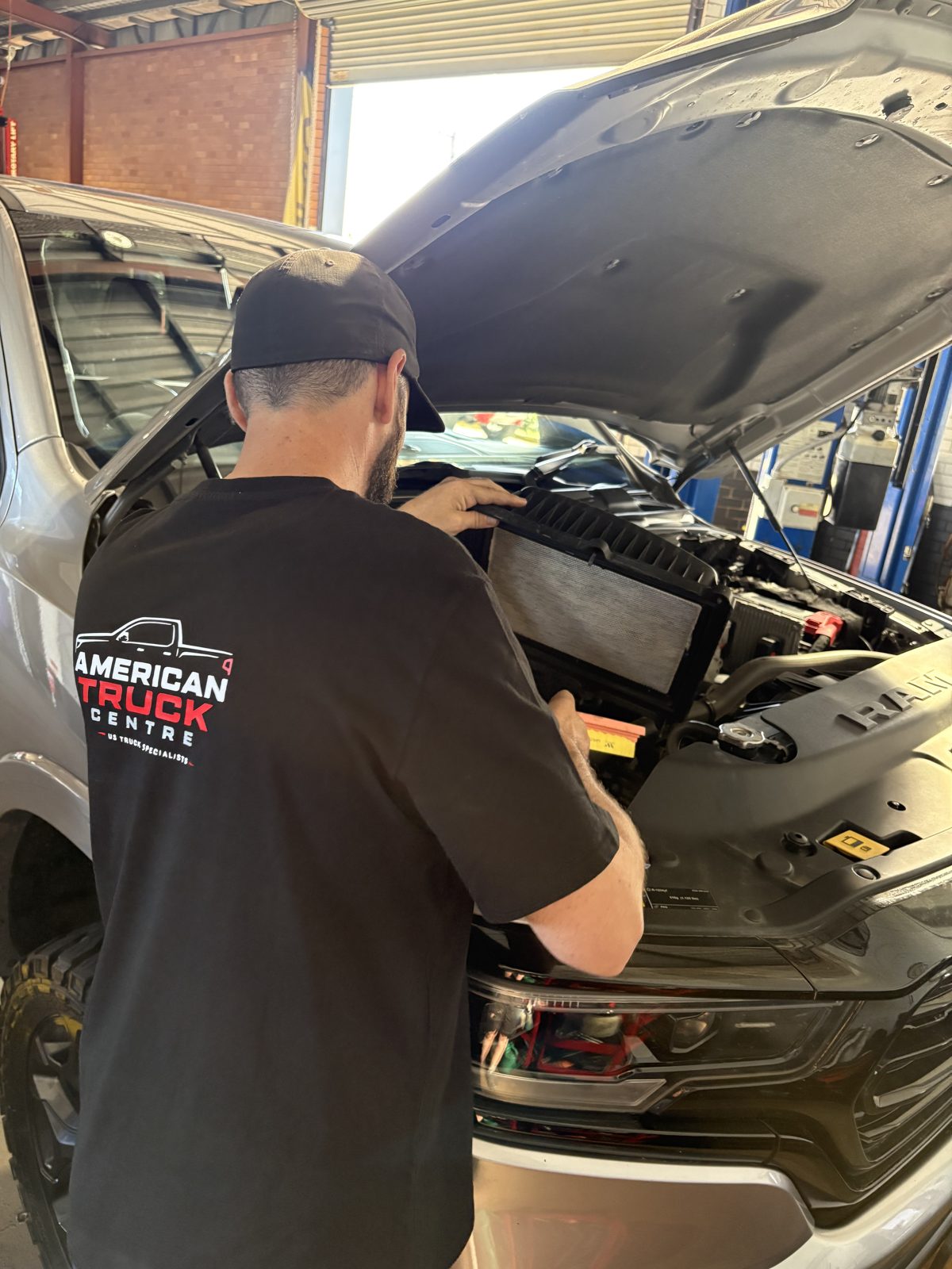Technician replacing the engine air filter on a RAM 1500
