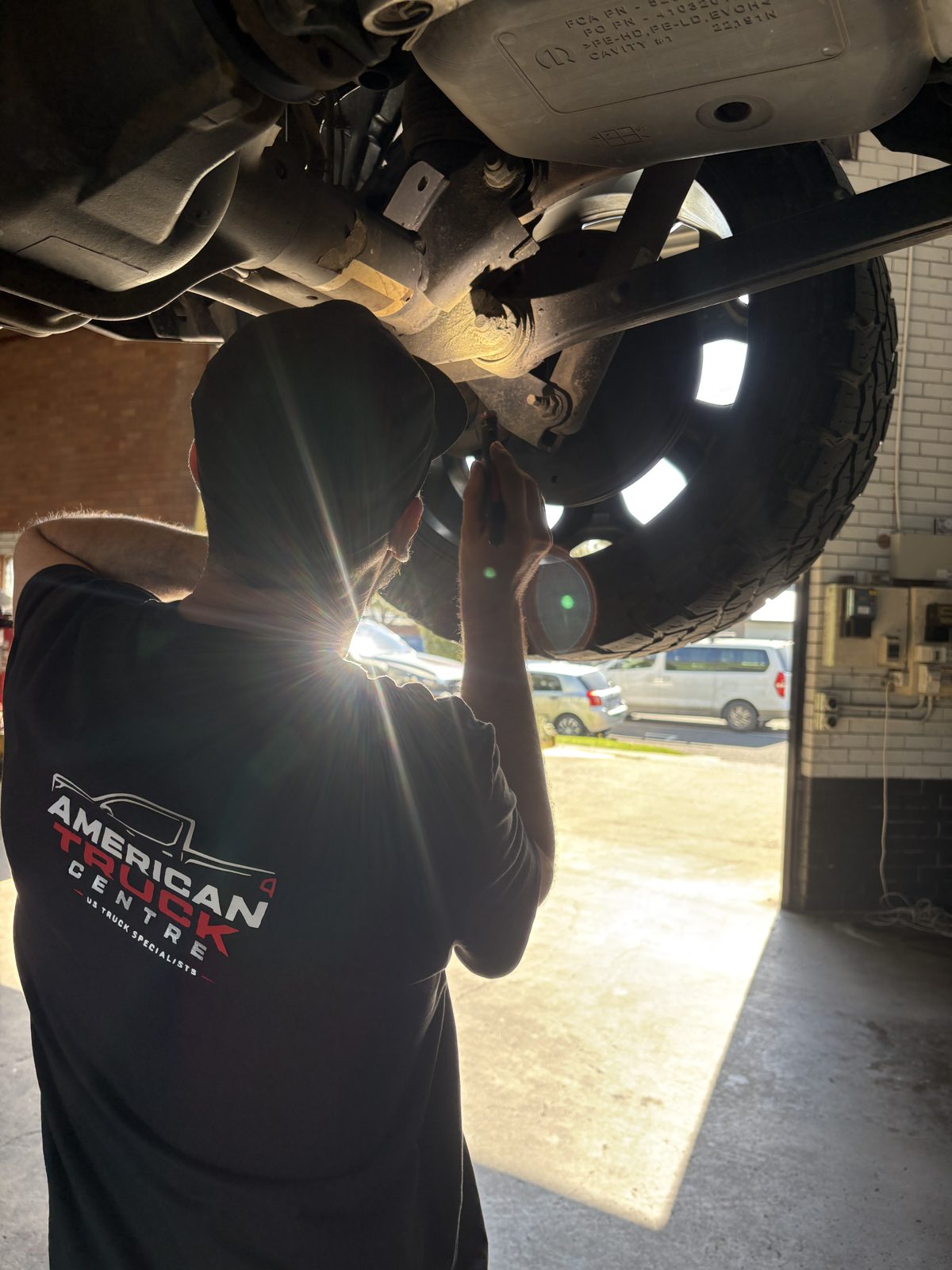 American Truck Centre technician inspecting the underbody of a RAM on the hoist