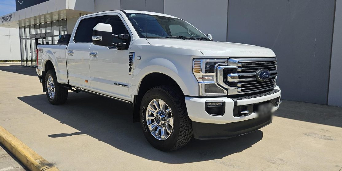White Ford F-250 Super Duty parked outside a workshop